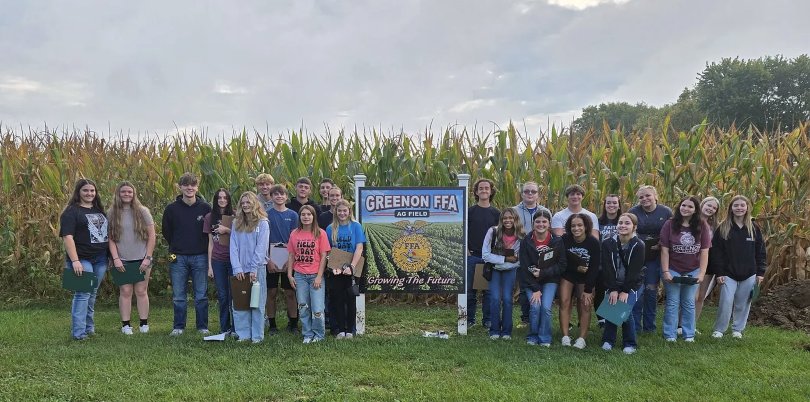 Greenon FFA students stand in front of a cornfield